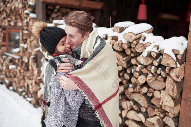 在冬季浪漫风景的小木屋里，一对快乐的年轻夫妇.