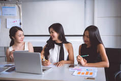 年轻的女企业家在办公室里集思广益。三美丽的亚洲妇女在办公室礼服一起谈论工作。办公室妇女在工作概念.