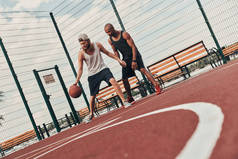 篮球场球场上两位朋友在户外打篮球的低角度观
