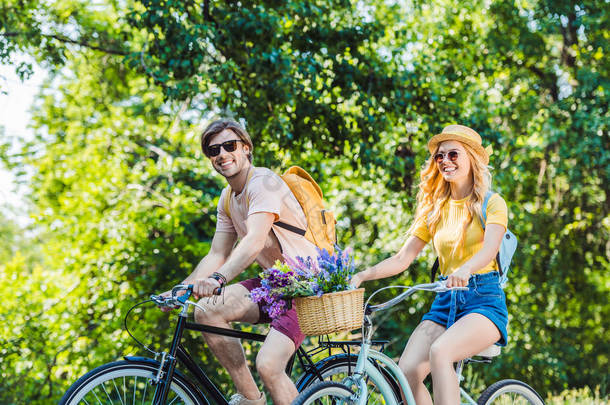 愉快的夫妇骑复古自行车在公园在夏<strong>天天</strong>