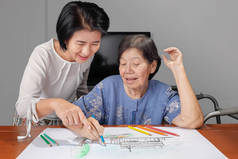 她带着女儿，在家里的爱好的绘图上的老妇绘画色彩
