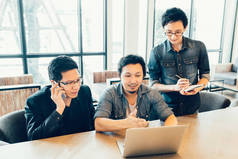 三个年轻的亚洲工友或在严重的业务会议或小组讨论集体讨论、 启动项目演示文稿或团队合作的概念，在咖啡厅或现代办公的大学生