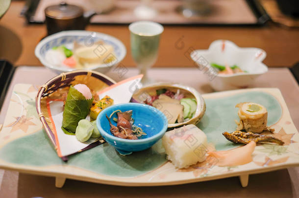 日本山梨河口湖传统日式旅馆的木桌上的日式晚餐套餐和开胃菜