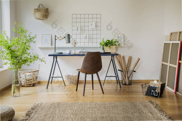 明亮的家庭办公室的真实的相片与地毯, 皮革椅子由书桌和新鲜的植物