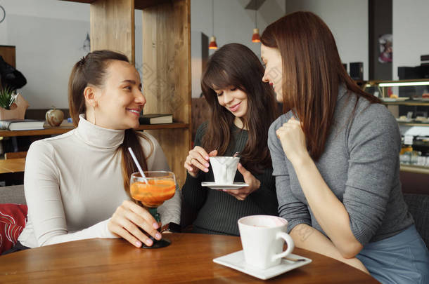 咖啡馆里有三个女女友在聊天和喝酒