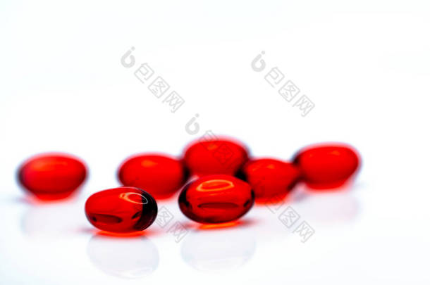 红色软胶囊胶囊丸分离在白色背景。红色软明胶胶囊堆。维生素和膳食补充剂的概念。制药业。药店。保健品.
