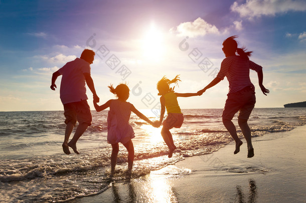 快乐的一家人一起在海滩上跳跃