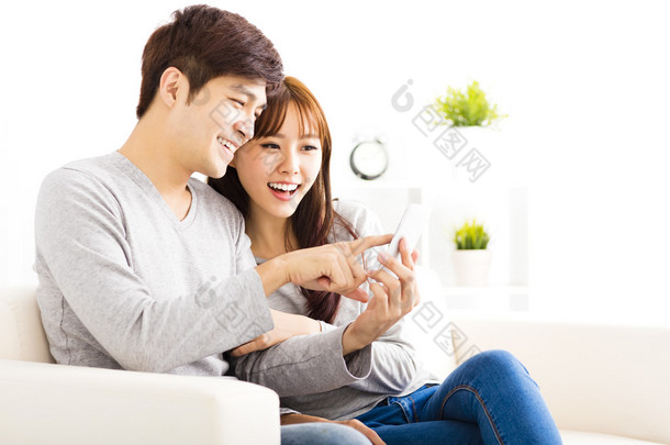 幸福夫妻看着在客厅里的智能手机
