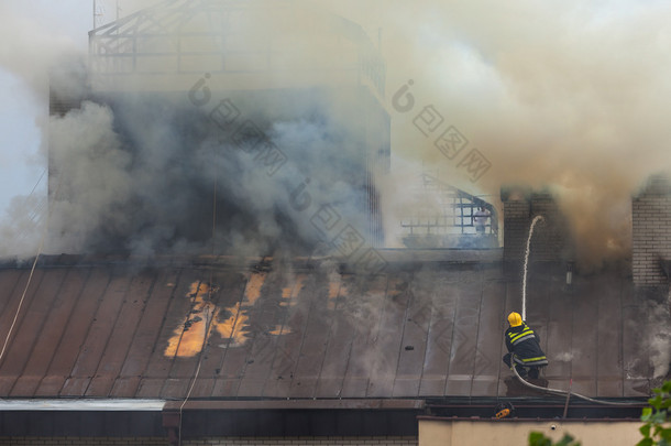 消防队员在灭火在屋顶上的工作
