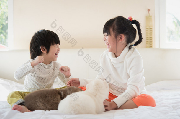 亚洲儿童在白色的床上接吻的小狗