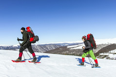 冬季徒步旅行。在山里徒步旅行带着背包和帐篷雪的冬天.