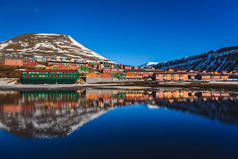 山水的北冰洋和反射与蓝蓝的天空和积雪，挪威斯匹次卑尔根，朗伊尔城，斯瓦尔巴德群岛的冬天山脉