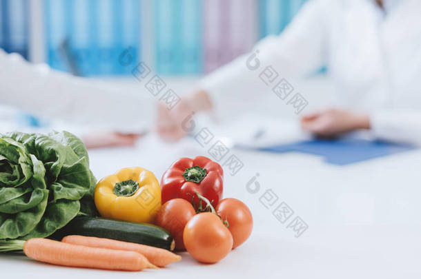 在办公室工作的专业营养学家和健康的<strong>新鲜蔬菜</strong>的前景: 饮食和健康概念