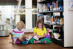 学校图书馆里的孩子。儿童阅读书籍.