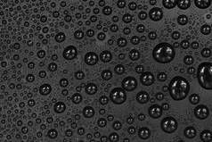 水滴在黑色背景纹理上.深色的背景玻璃上布满了水滴.水中的灰色气泡