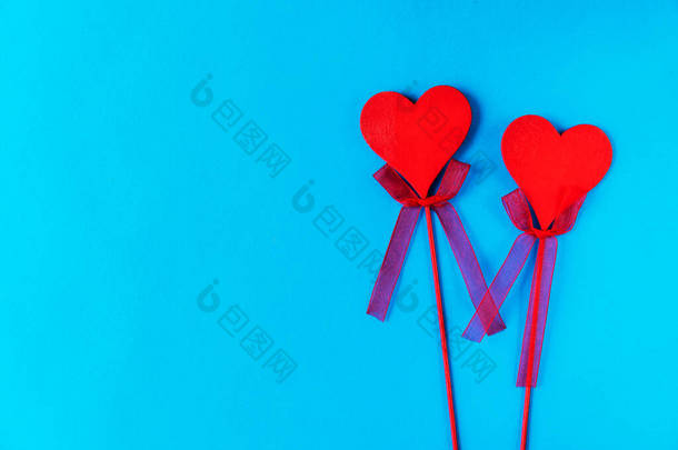 两个红色的木制心脏，杆子上有弓形的蓝色背景。有一个地方的文字。可以在计算机台式机上或在电话屏幕保护程序上使用。或者像明信片一样