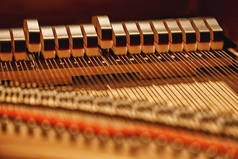 在钢琴里面。钢琴内的锤和弦的特写画面。音乐乐器