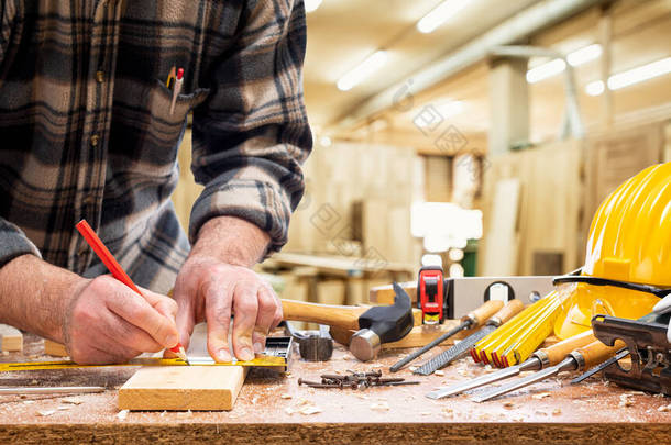 特写。 用铅笔和木匠正方形的木匠在木板上画出切割线. 建筑业、木工车间.