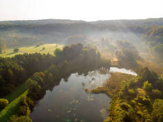 清晨空中俯瞰树木和河流.秋天,雾蒙蒙的森林景色美丽,树叶呈橙色和黄色.立陶宛维尔纽斯的秋天城市公园风景