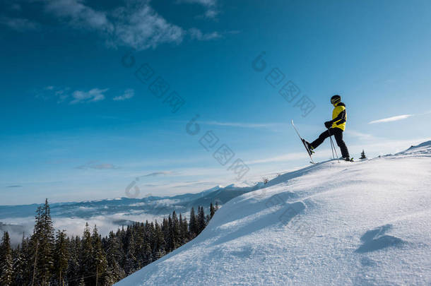 滑雪者手持滑雪手杖，在蓝天的映衬下迈步<strong>滑行</strong>的侧视图 