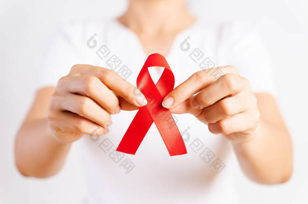 特写女<strong>人手</strong>控股红丝带艾滋病毒，世界艾滋病日宣传功能区。医疗保健和医学的概念.