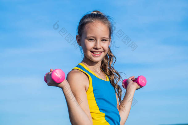 快乐的少女穿着运动服参加有杠铃的空中训练，参加体能训练