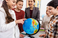 教师和学生在课堂上学习地理时看地球