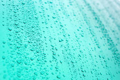 蓝色背景上的雨滴.夏天的雨滴闭包视图.