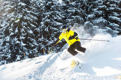 在松林附近的雪地上滑雪时，戴着护目镜拿着滑雪棒的运动员 