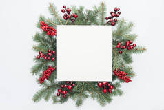 在白色的中间查出的圣诞树花圈与圣诞节装饰和方形空白空间的顶部视图