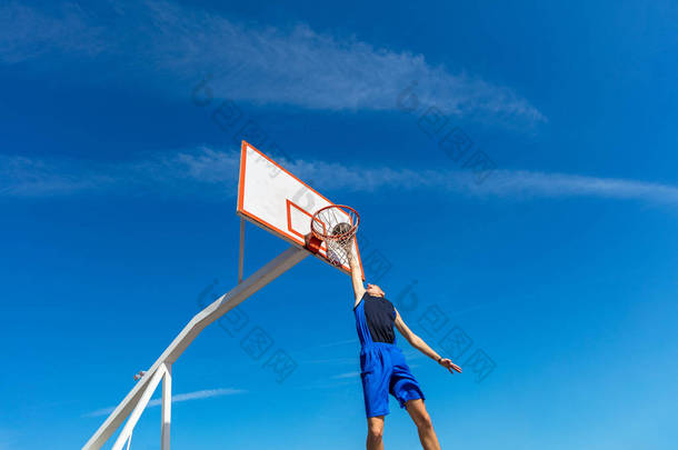 年轻的篮球街球员做灌篮扣篮