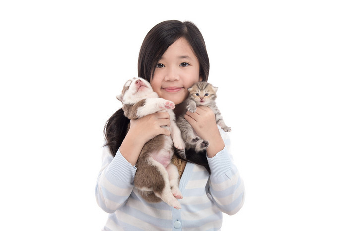 美丽的亚洲女孩抱着刚出生的小狗和小猫
