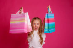 一个穿着粉色背景的购物袋的小女孩 