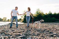 幸福的年轻夫妇与狗在 roadtrip 的肖像。男人和女人坐在格子上户外野餐概念.