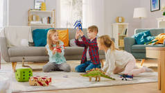 在客厅里：男孩和女孩玩玩具飞机和恐龙，而坐在地毯上。阳光明媚的客厅，孩子们玩得开心.