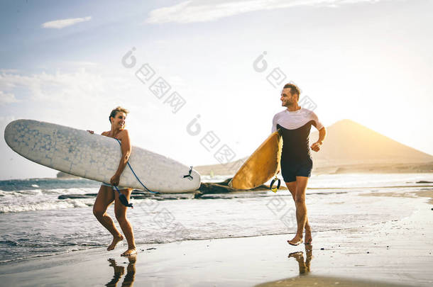 年轻夫妇的冲浪者运行与冲浪板海滩上的夕阳-快乐的恋人一起冲浪-人, 运动和生活方式概念-<strong>老式</strong>过滤器-关注妇女板