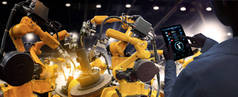 工厂的女工业工程师在智能化工厂的自动化机械臂机器上进行实时监测系统软件的工作。数字未来制造.