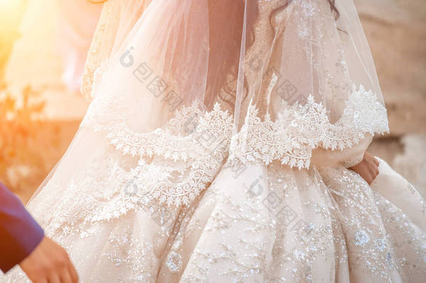 新娘服装面料的细节和漂亮绣花婚纱的概念被用作插图和文字的背景。部分白色豪华婚纱的特写图像