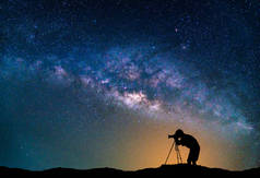景观与银河系。夜空的星星与摄影师拍照在山上.