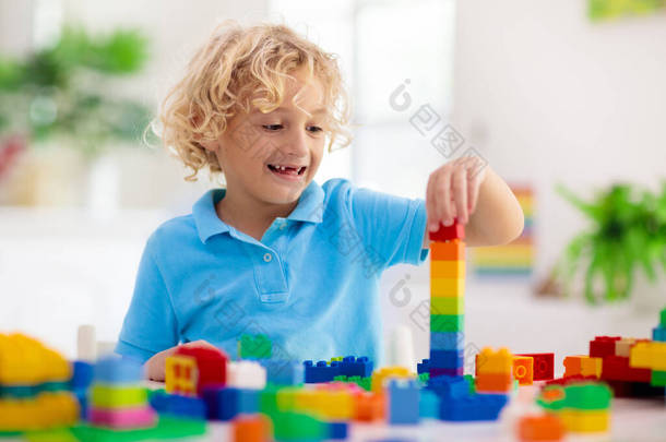 孩子们玩五彩缤纷的方块.小男孩在家里或托儿所建塔。幼儿教育玩具。为婴儿或幼儿构建创意游戏。幼稚园游戏室的烂摊子.