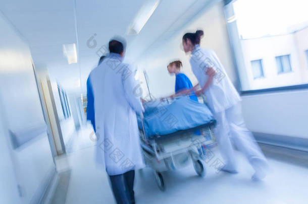 病人在担架或担架到急救室的医生与<strong>护士</strong>在医院走廊通过速度推上运动模糊的照片