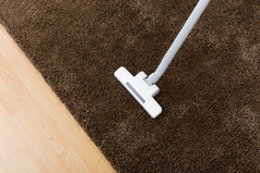 用真空吸尘器在客厅里的棕色地毯