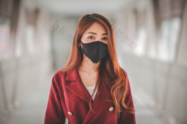 亚洲妇女戴口罩保护pm2.5，并在<strong>公众</strong>场合咳嗽感染Covid-19病毒.