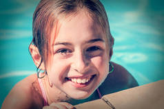3.女孩在游泳池里游泳的时候向一边看。在游泳池里游泳的时候，兴奋地把目光移开。快乐的童年。放松的概念。在游泳池边放松，微笑，少年