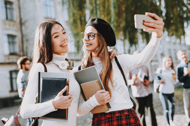 快乐在一起。塞尔菲女孩。学生。庭院。书。站在大学里。心情很好大学。知识。建筑。<strong>幸福</strong>。情报。庆祝。校园。伙计, 朋友。快乐.