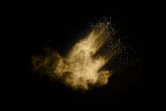 黑色背景下的金色粉末爆炸彩云。五颜六色的灰尘爆炸了.油漆Holi.