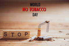 世界无烟日, 5月31日。在木制餐桌背景上, 用木块上的停止文字封闭断烟.