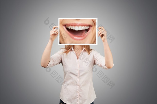 女人拿着灿烂的笑容与张照片.