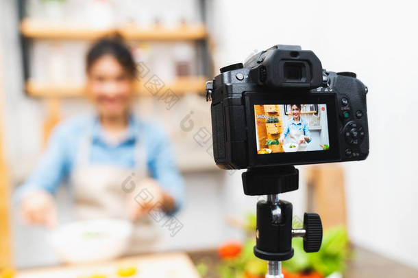 年轻可爱的亚洲博主女孩录制视频教程<strong>课程</strong>沙拉烹饪课在家里的厨房。食品博客或博客, 社交媒体爱好广播, 或在线学习<strong>课程</strong>概念