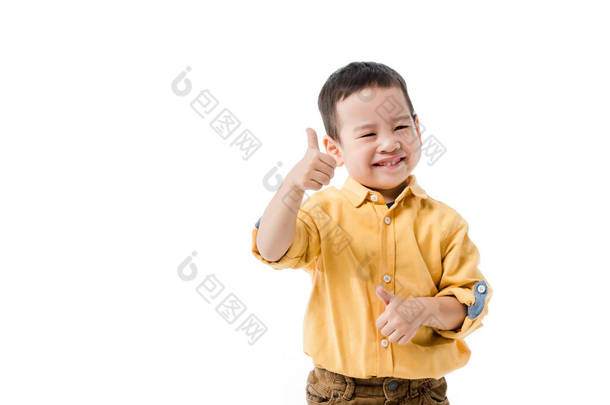 一个快乐的亚洲小男孩孤零零地躺在白色的树上，露出大拇指